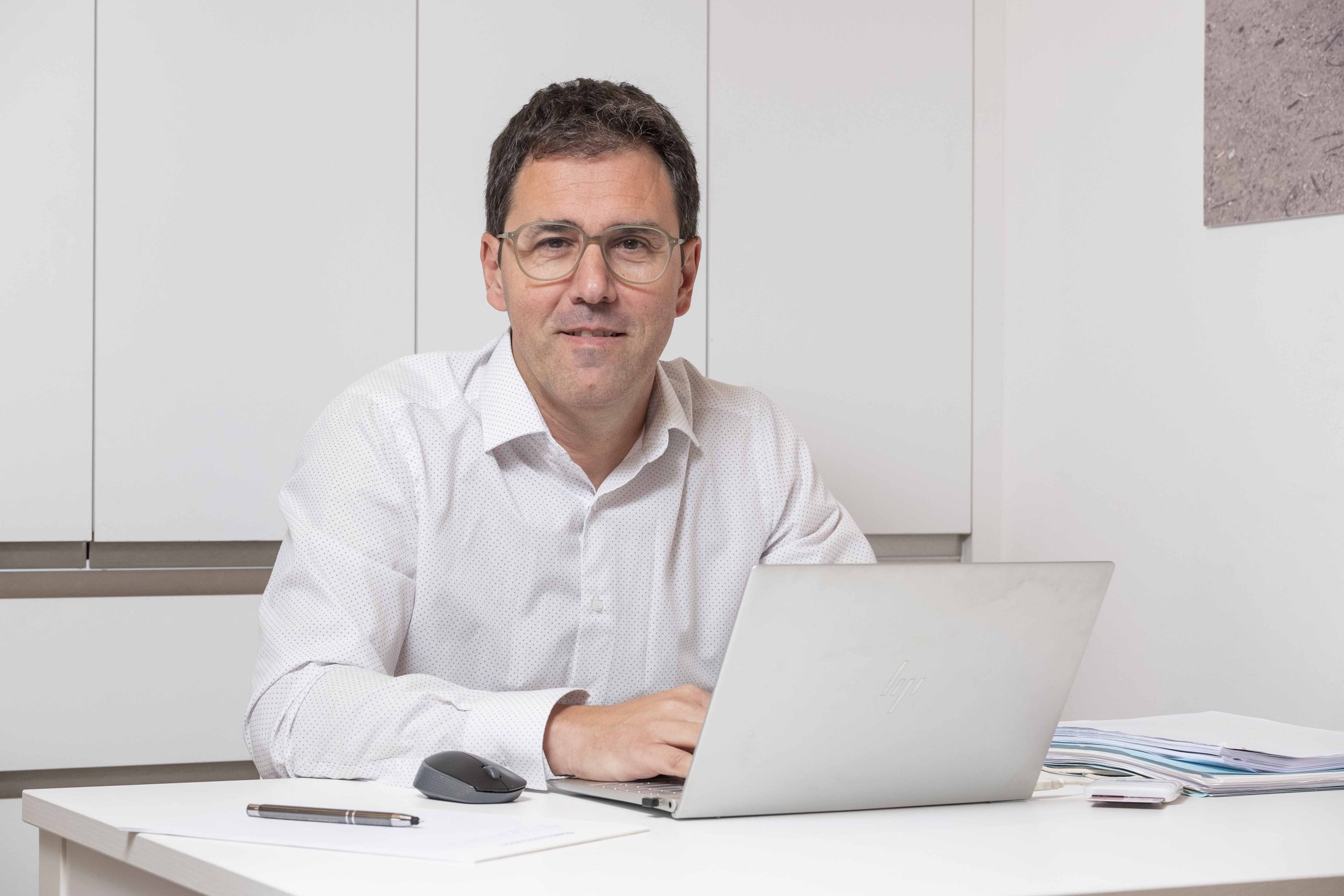 Andreu Sánchez abogado de riesgos laborales mirando a cámara en su despacho